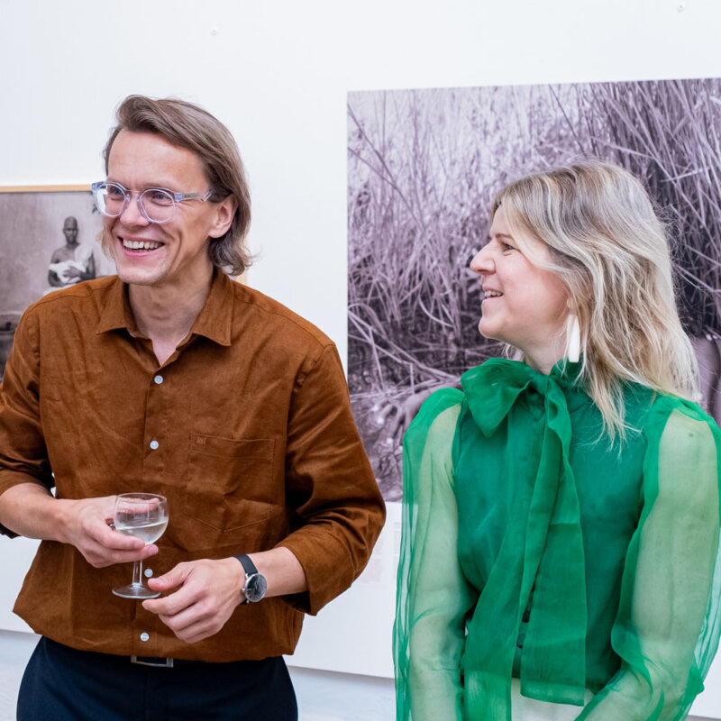 Dokfoto Keskuse kuraatorid ja juhid Toomas Järvet ja Kristel Laur naeravad Angelika Kollini näituse avamisel Angelika tööde taustal